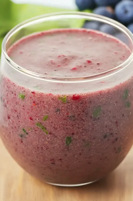 A glass of smoothie with a straw in it.