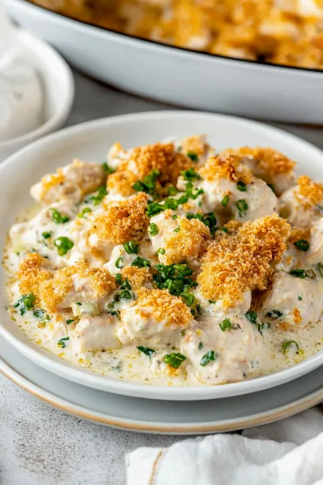 A bowl of food with chicken and vegetables.