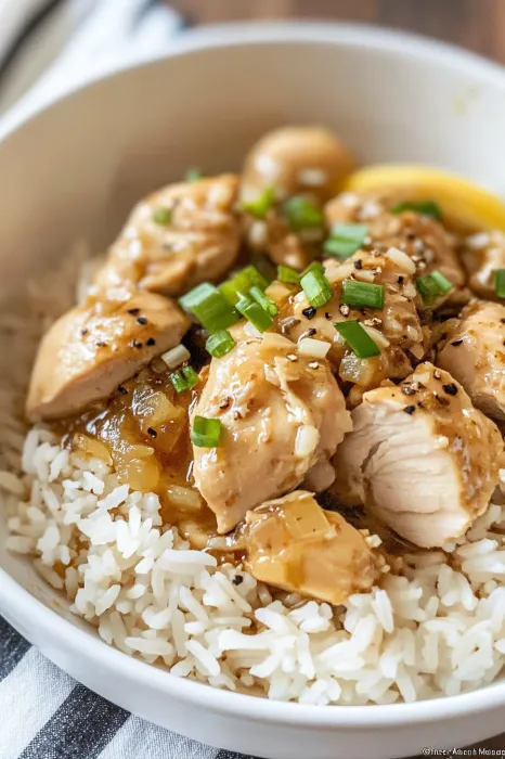 A bowl of rice with chicken and vegetables.