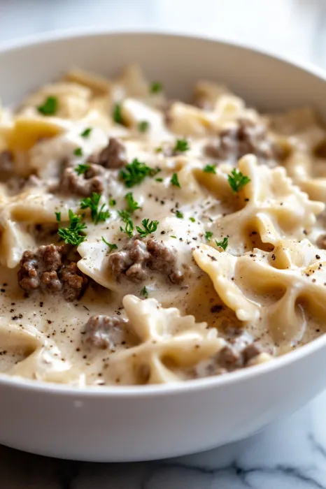 A bowl of pasta with meat and cheese.
