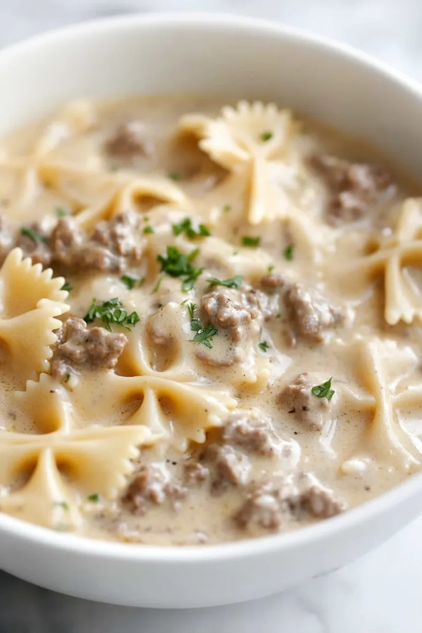 A bowl of pasta with meat and cheese.