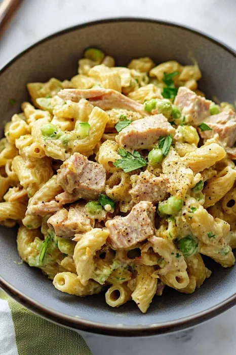 A bowl of pasta with meat and peas.