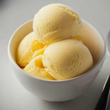 A bowl of ice cream with two scoops.